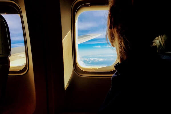 ragazza guardando fuori dalla finestra di un aereo
