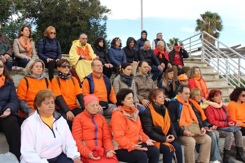 Grupo meditando vestido de laranja - Itália