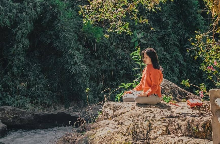 mulher meditando em uma floresta