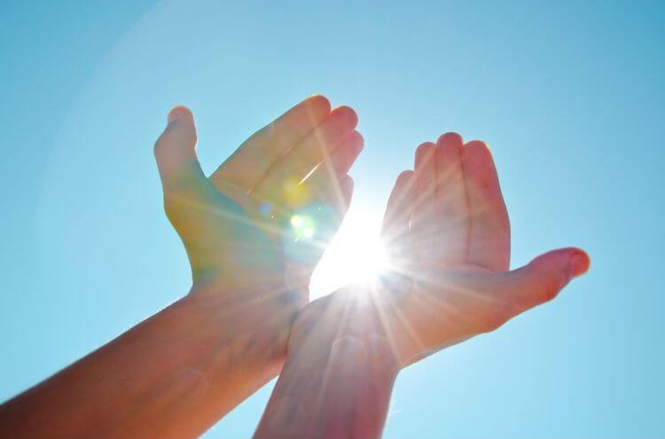mãos segurando a luz do sol